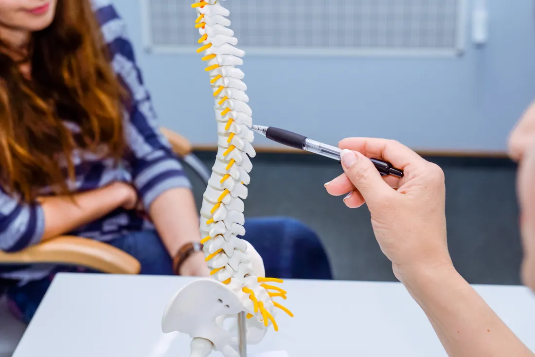Chiropractor explaining a spine model in Bentonville, AR